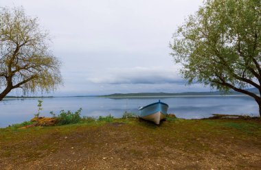 Ulubat Gölü, Golyazi, Bursa, Türkiye 'deki balıkçı tekneleri, büyük ağaç gölleri, gün batımı manzarası