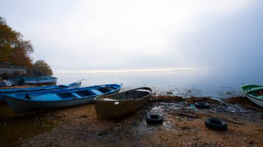 Ulubat Gölü, Golyazi, Bursa, Türkiye 'deki balıkçı tekneleri, büyük ağaç gölleri, gün batımı manzarası