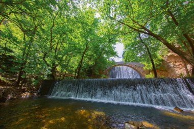 Eski taş, kemerli köprü, Palaiokaria, Trikala vilayeti, Thessaly, Yunanistan 'daki iki şelale arasında.