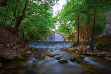 The old stone, arched bridge, between two waterfalls in Palaiokaria, Trikala prefecture, Thessaly, Greece.