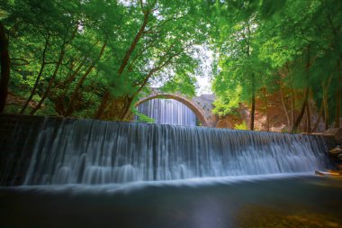 Eski taş, kemerli köprü, Palaiokaria, Trikala vilayeti, Thessaly, Yunanistan 'daki iki şelale arasında.