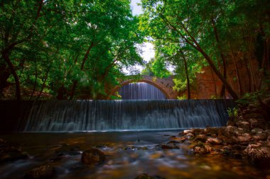 Eski taş, kemerli köprü, Palaiokaria, Trikala vilayeti, Thessaly, Yunanistan 'daki iki şelale arasında.