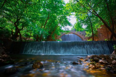 Eski taş, kemerli köprü, Palaiokaria, Trikala vilayeti, Thessaly, Yunanistan 'daki iki şelale arasında.