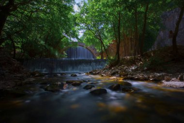 Eski taş, kemerli köprü, Palaiokaria, Trikala vilayeti, Thessaly, Yunanistan 'daki iki şelale arasında.