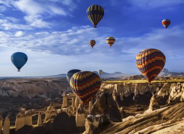 Muhteşem Kapadokya manzarası. Anadolu 'da güneş doğarken gökyüzünde renkli uçan balonlar. Türkiye 'nin Goreme kentinde tatil