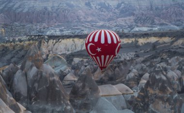 Muhteşem Kapadokya manzarası. Anadolu 'da güneş doğarken gökyüzünde renkli uçan balonlar. Türkiye 'nin Goreme kentinde tatil