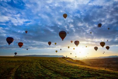 Muhteşem Kapadokya manzarası. Anadolu 'da güneş doğarken gökyüzünde renkli uçan balonlar. Türkiye 'nin Goreme kentinde tatil