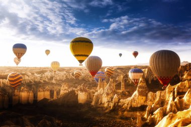 Muhteşem Kapadokya manzarası. Anadolu 'da güneş doğarken gökyüzünde renkli uçan balonlar. Türkiye 'nin Goreme kentinde tatil