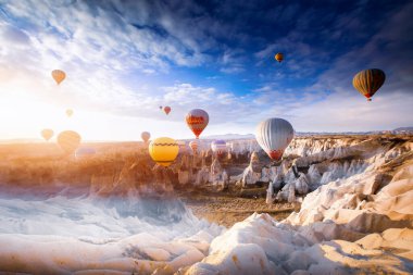 Muhteşem Kapadokya manzarası. Anadolu 'da güneş doğarken gökyüzünde renkli uçan balonlar. Türkiye 'nin Goreme kentinde tatil