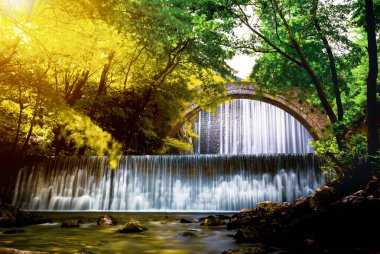 The old stone, arched bridge, between two waterfalls in Palaiokaria, Trikala prefecture, Thessaly, Greece.