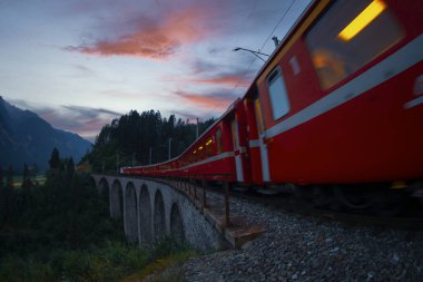 Dağda viyadük üzerinde İsviçre kırmızı treni, manzaralı yolculuk