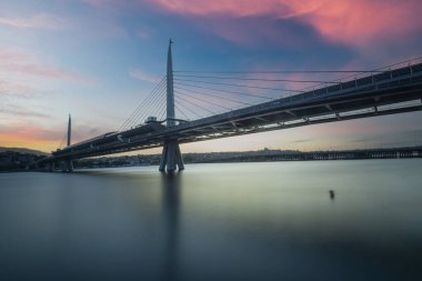 İstanbul metro istasyonu gün batımında Golden Horn 'daki modern köprüde.