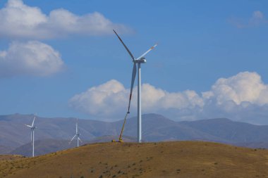 Mavi gökyüzünde dağda tarlada duran vahşi değirmen
