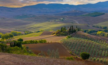 Arka planda Val d 'Orcia tepeleri olan Ascanio yakınlarındaki bir çiftlik evinin panoramik görüntüsü