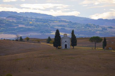 Arka planda Val d 'Orcia tepeleri olan Ascanio yakınlarındaki bir çiftlik evinin panoramik görüntüsü