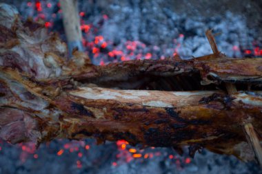 Kamp ateşinde bütün bir kuzuyu pişirmek