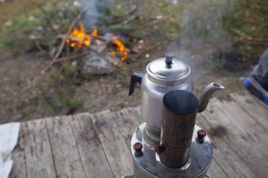 Kamp ateşinin üstünde semaverde çay