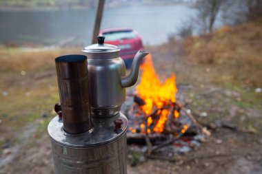 Kamp ateşinin üstünde semaverde çay
