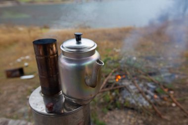 Kamp ateşinin üstünde semaverde çay