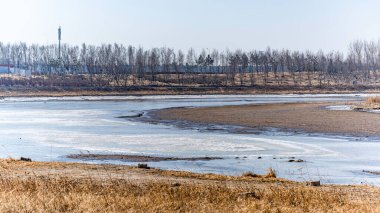 Çin, Changchun 'daki Yitong Nehri boyunca eriyen buz ve karla kaplı bir manzara.
