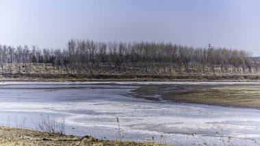 Çin, Changchun 'daki Yitong Nehri boyunca eriyen buz ve karla kaplı bir manzara.