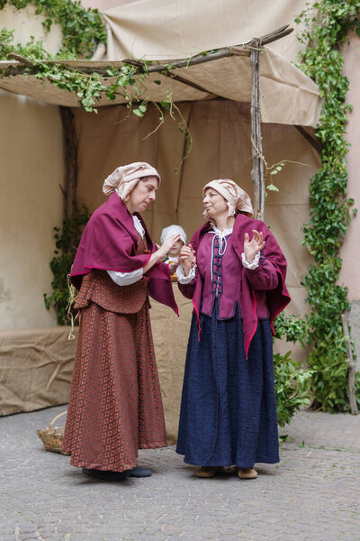 Taggia, Italy - February 26, 2023: Participants of historical reenactment in the old town of Taggia, in Liguria region of Italy. The actors acting out episodes of daily life in settings that evoke moments of life lived fully the seventeenth century. 