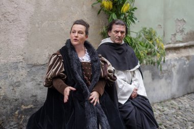Taggia, İtalya - 26 Şubat 2023: İtalya 'nın Liguria bölgesindeki eski Taggia kasabasında tarihi yeniden canlandırmanın katılımcıları. Aktörler günlük hayatın bölümlerini canlandırıyorlar. Hayatın anlarını anımsatan ortamlarda. Tam olarak 17. yüzyılı yaşadılar.. 