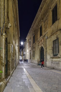 Lecce, İtalya - 30 Ekim 2023: Lecce, Apulia, İtalya 'nın şehir merkezinde gece manzaralı cadde