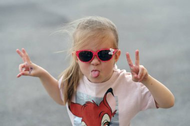 Bir çocuk kameraya bakıyor, yüzünü buruşturuyor.