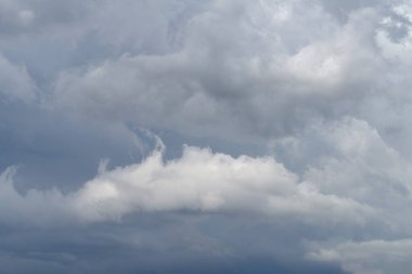 Daha küçük kümülüs bulutları eşliğinde yükselen kümülonimbus bulutları