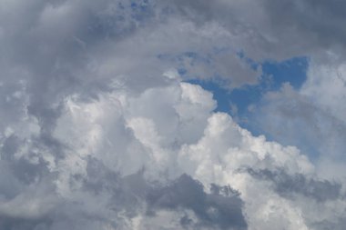Daha küçük kümülüs bulutları eşliğinde yükselen kümülonimbus bulutları