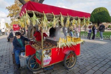 İstanbul, Türkiye - 10 Kasım 2024: İstanbul Sultanahmet ilçesinde yerel satıcılar kızarmış kestane ve kızarmış mısır satıyor