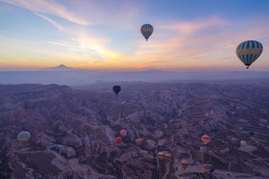 Goreme, Türkiye - 13 Kasım 2024: Kapadokya, Türkiye 'de kaya üzerinde uçan sıcak hava balonları