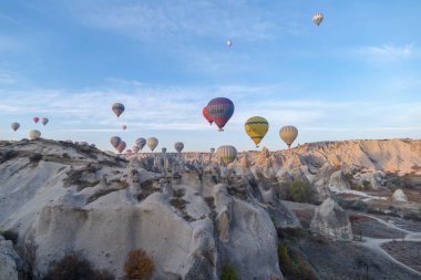 Goreme, Türkiye - 13 Kasım 2024: Kapadokya, Türkiye 'de kaya üzerinde uçan sıcak hava balonları
