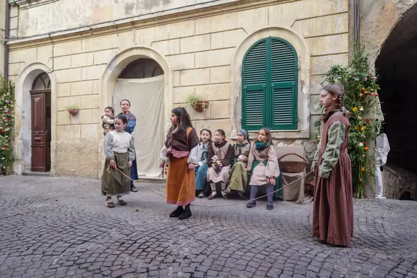 Taggia, İtalya - 25 Şubat 2024: İtalya 'nın Liguria bölgesindeki eski Taggia kasabasında tarihi yeniden canlandırmanın katılımcıları. Aktörler günlük hayatın bölümlerini canlandırıyorlar. Hayatın anlarını anımsatan ortamlarda. Tam olarak 17. yüzyılı yaşadılar.. 