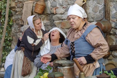 Taggia, İtalya - 25 Şubat 2024: İtalya 'nın Liguria bölgesindeki eski Taggia kasabasında tarihi yeniden canlandırmanın katılımcıları. Aktörler günlük hayatın bölümlerini canlandırıyorlar. Hayatın anlarını anımsatan ortamlarda. Tam olarak 17. yüzyılı yaşadılar.. 