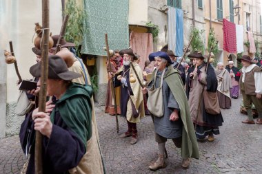 Taggia, İtalya - 23 Şubat 2025: İtalya 'nın Liguria bölgesindeki eski Taggia kasabasında tarihi yeniden canlandırmanın katılımcıları. Aktörler günlük hayatın bölümlerini canlandırıyorlar. Hayatın anlarını anımsatan ortamlarda. Tam olarak 17. yüzyılı yaşadılar.. 