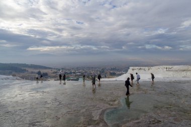 Pamukkale, Türkiye - 15 Kasım 2024: Pamukkale 'de akan suyun teraslarında yürüyen insanlar Denizli' deki Menderes Vadisi 'nde yer almaktadır (Türkçe 