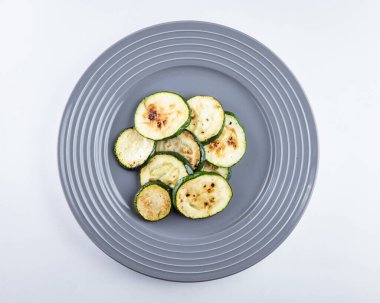 Grilled zucchini at grey plate. Side dish with zucchini top view.