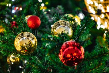 Rengarenk süslemelerle süslenmiş neşeli bir Noel ağacı, tatil ruhuyla dolu, rahat ve tozlu bir odaya ılık bir parıltı saçıyor.