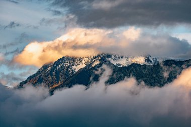 İnce Bulutlarla Kaplanmış Görkemli Tepeler Yumuşak Işık ve Göksel Sis ile yıkanmış Kar Kaplamalı Dağların Sakin Kış Manzarası.