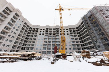 Kışlar Bitmemiş Bir Rüyayı Duraklatır - Karla dolu bir inşaat sahasında, kışın soğuğunda etrafa saçılmış malzemelerin üzerine bir vinç gibi yarı biçimlenmiş çok katlı bir bina sergilenir..!