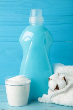 Eko yıkama konsepti. Çamaşır deterjanı, pamuk çiçekleri ve gri arka planda pembe süveter, fotokopi alanı. Üst görünüm