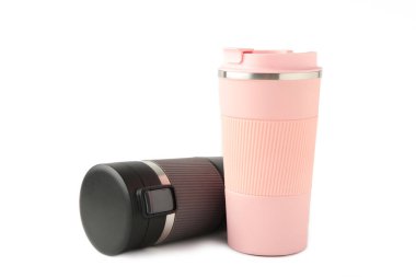 Beyaz arka planda izole edilmiş çay ya da kahve için iki termo bardak ya da termos bardağı. Adam ve kadın için siyah ve pembe. Çiftler için sıcak içecek. Üst görünüm