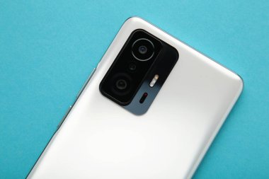 Cep telefonu kamerası, mavi arka planda flaş lens. Üst görünüm