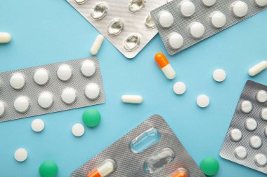 Supplements and pills blister packs on blue background. Pharmacists and clinics. Top view