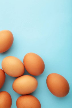 Chicken eggs on yellow background. Farm products, natural eggs. Top view