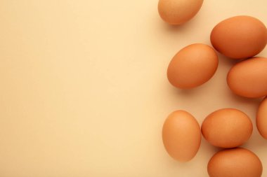 Chicken eggs on beige background. Farm products, natural eggs. Top view