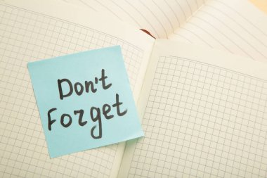 Open notepad and sticky notes with word don't forget. Top view