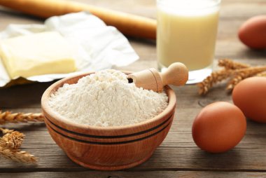 Ingredients for baking or cooking, egg flour, rolling pin butter, milk on a grey wooden background Cookie pie or cake recipe. Top view.